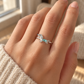 Dainty dachshund crystal ring worn on a hand beside a window